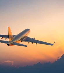 Passanger airplane flying above clouds in evening.